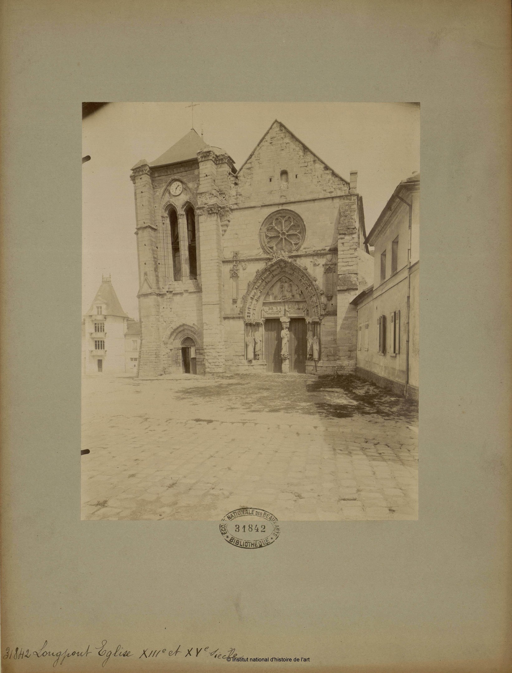 Altes Foto einer Kirche in einer Stadtstraße, gerahmt und von anderen Gebäuden umgeben.
