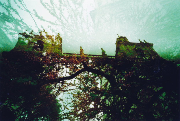 Ein historisches Bauwerk mit einer von Bäumen umgebenen Brücke.