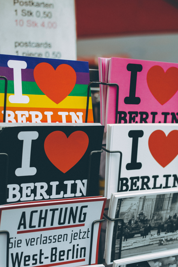 Ein Gestell mit verschiedenen Büchern und Postern mit der Aufschrift "Ich liebe Berlin" vor einem leicht unscharfen Hintergrund.