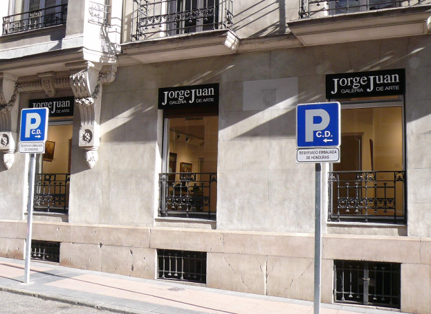 Ein mehrstöckiges Gebäude mit Fenstern, Geländern, Türen und Säulen, das Werbetafeln auf Pfählen entlang des Gehwegs und sichtbare Innenobjekte aufweist, die auf eine belebte städtische Umgebung hinweisen.