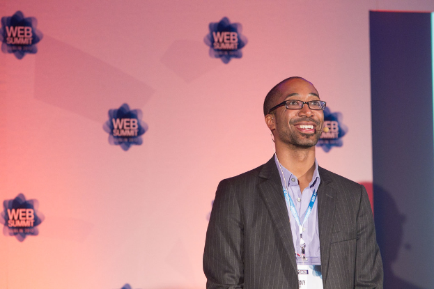 Eine Person steht in der Mitte des Bildes mit Werbung im Hintergrund.