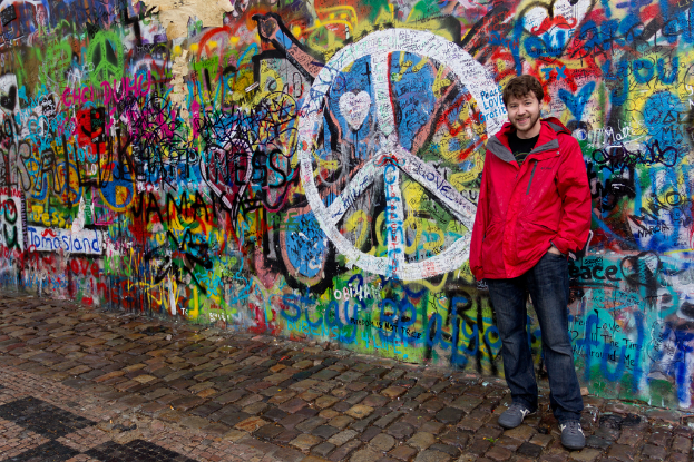 Eine Person steht vor einer Wand mit Graffiti, mit einem Weg am Boden.