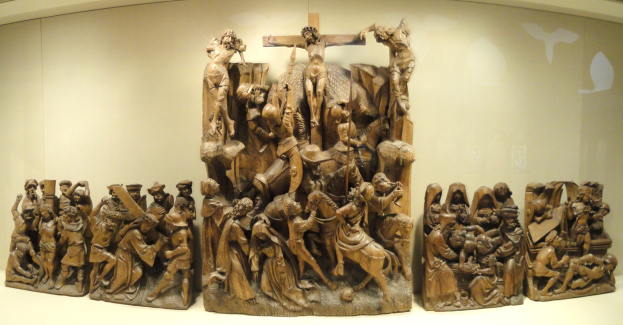 Eine Gruppe von Holzskulpturen, die gemeinsam in einem Museum ausgestellt sind.