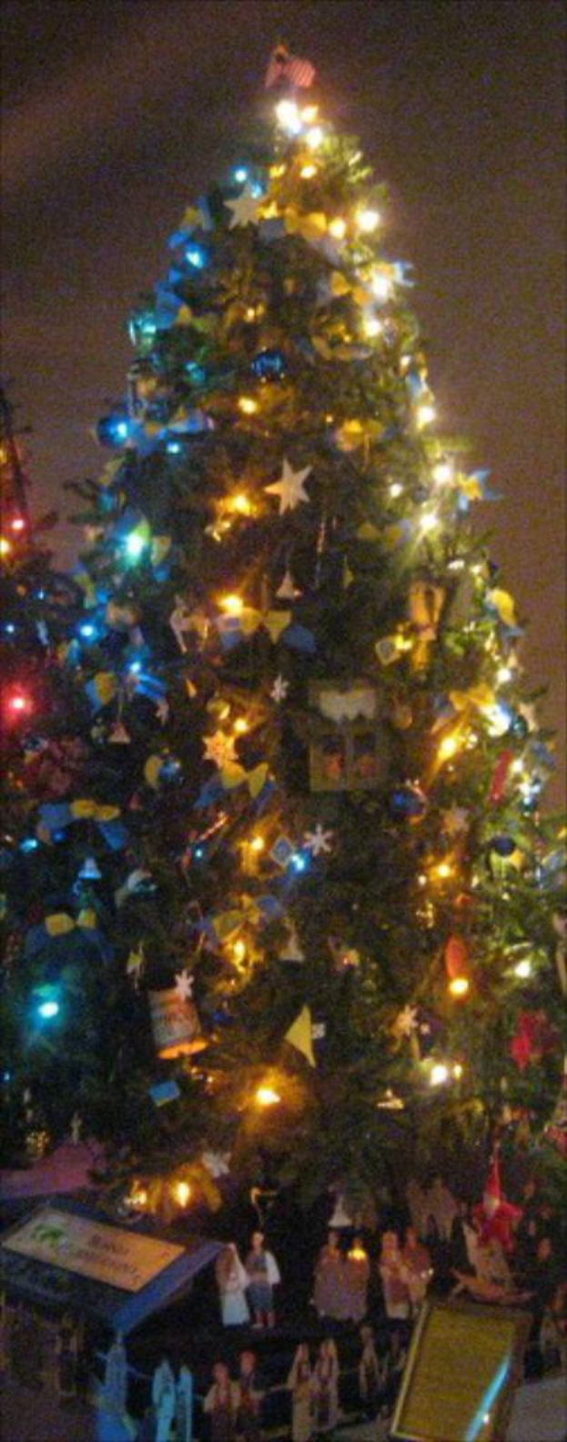 Ein geschm{"u}ckter Weihnachtsbaum mit Statuen von Menschen darauf.