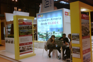 Ein Raum mit Menschen, die an einem Tisch arbeiten, umgeben von mehreren Flyern mit verschiedenen Werbeanzeigen.