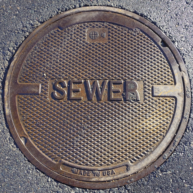 Metall-Schachtobel auf der Straße mit der eingravierten Aufschrift "Kanal"