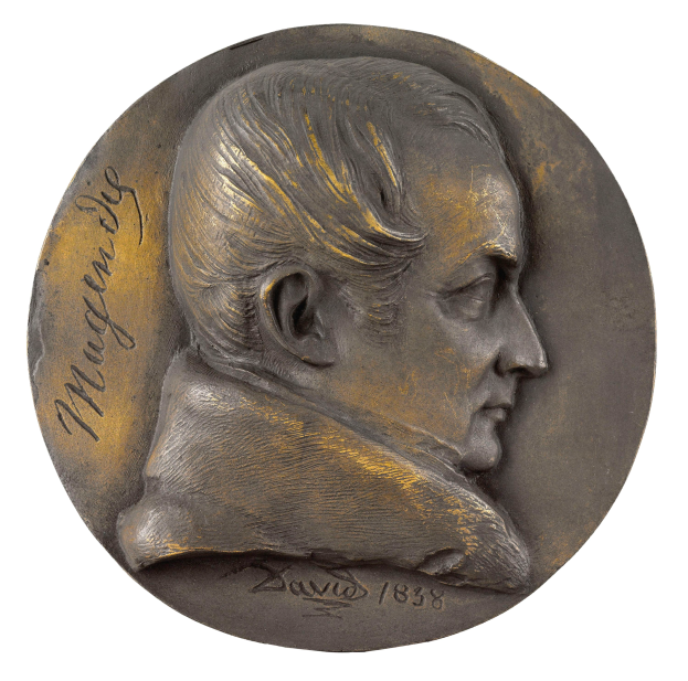 Eine Bronzemedaille mit einem Profilbild eines Mannes in Anzug und ernstem Gesichtsausdruck, darauf die Inschrift "Mugendig".