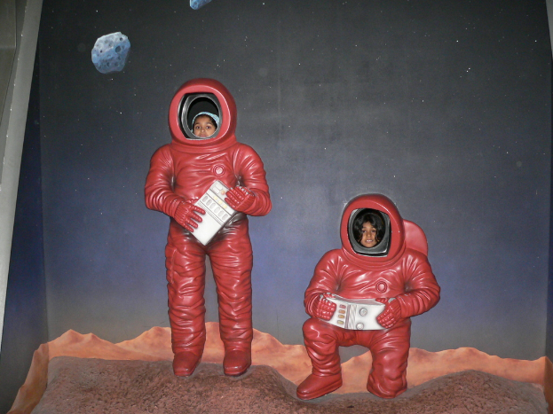 Ein Plakat mit Astronauten, auf deren Gesichter Kinderköpfe aufgeklebt sind.