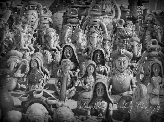 Mehrere Ganesha-Idole umgeben von Frauen und Männern