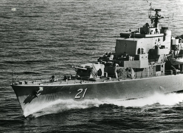 Ein Schwarz-Weiß-Foto eines großen gelenkten Raketenfregatters, das auf dem Wasser fährt und eine sichtbare Identifikationsnummer an seiner Seite trägt.