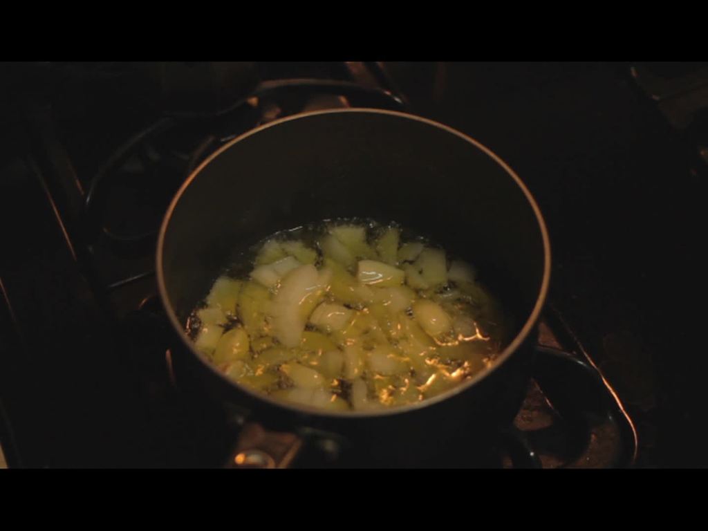 Ein Herd mit einem Gefäß, in dem Essen darauf gekocht wird.