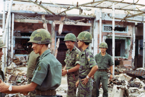 Ein abgerissenes Haus mit ein paar Soldaten in der Nähe.