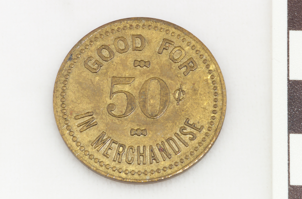 Eine Goldmünze mit der Aufschrift "Gut für 50 in Waren" vor einem weißen Hintergrund.