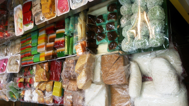 Verkaufsregal in einem Convenience-Store mit verschiedenen verpackten Lebensmitteln in Polyethylen-Hüllen.