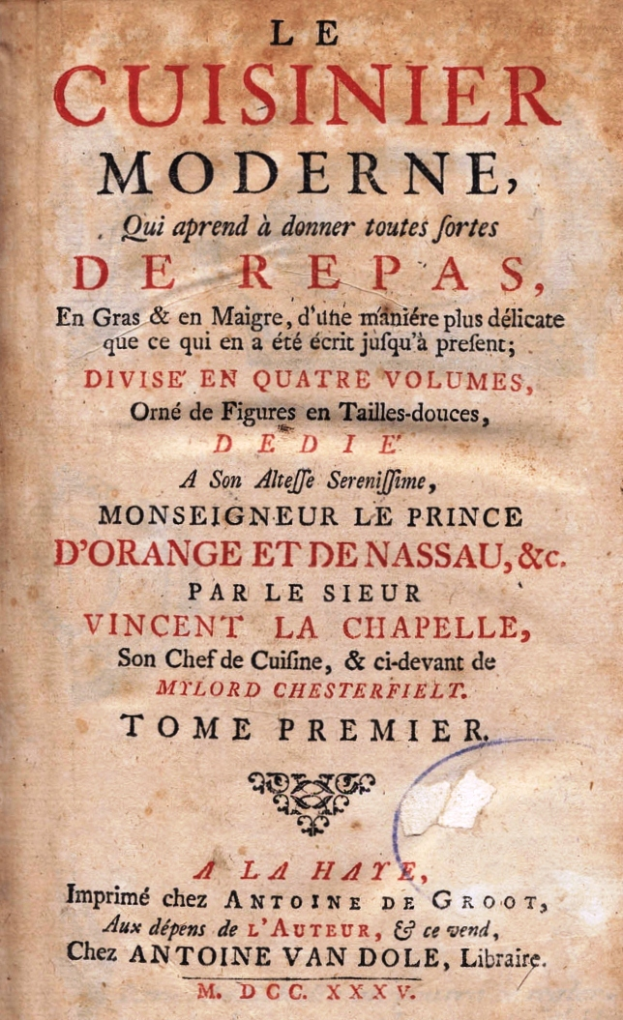 Ein altes Buch mit dem Titel 'Le Cuisinier Moderne, Derepas' liegt aufgeschlagen da, das eine Seite mit französischem Text zeigt.