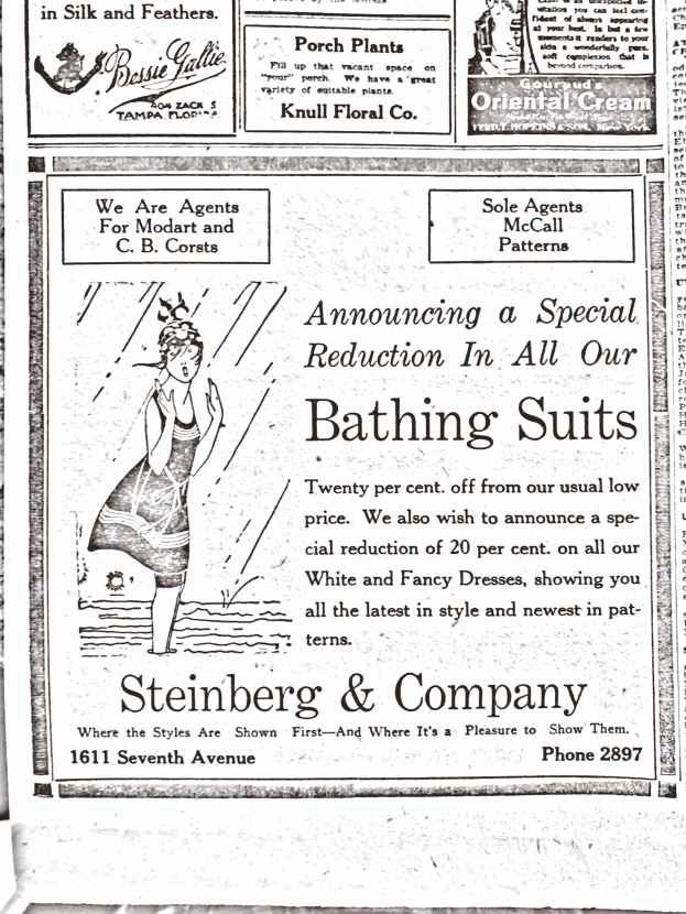 Eine Frau in einem weißen hochgeschlossenen, langärmeligen Kleid mit ihrem Haar in einem Dutt, die zentral in einer Werbung für Steinberg & Company's Badesachen steht, umgeben von Text.