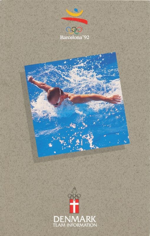 Schwimmer in blauem Schwimmanzug mit ausgestreckten Armen im Wasser, mit Logo und Text "Olympische Spiele Barcelona 1992" und "Danemark-Team-Informationen" auf einem Plakat mit einem hellblauen Himmel mit weißen Wolken.