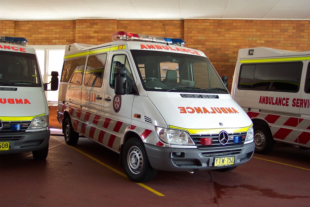 Ein Rettungswagen in Weiß vor einer Backsteinwand geparkt