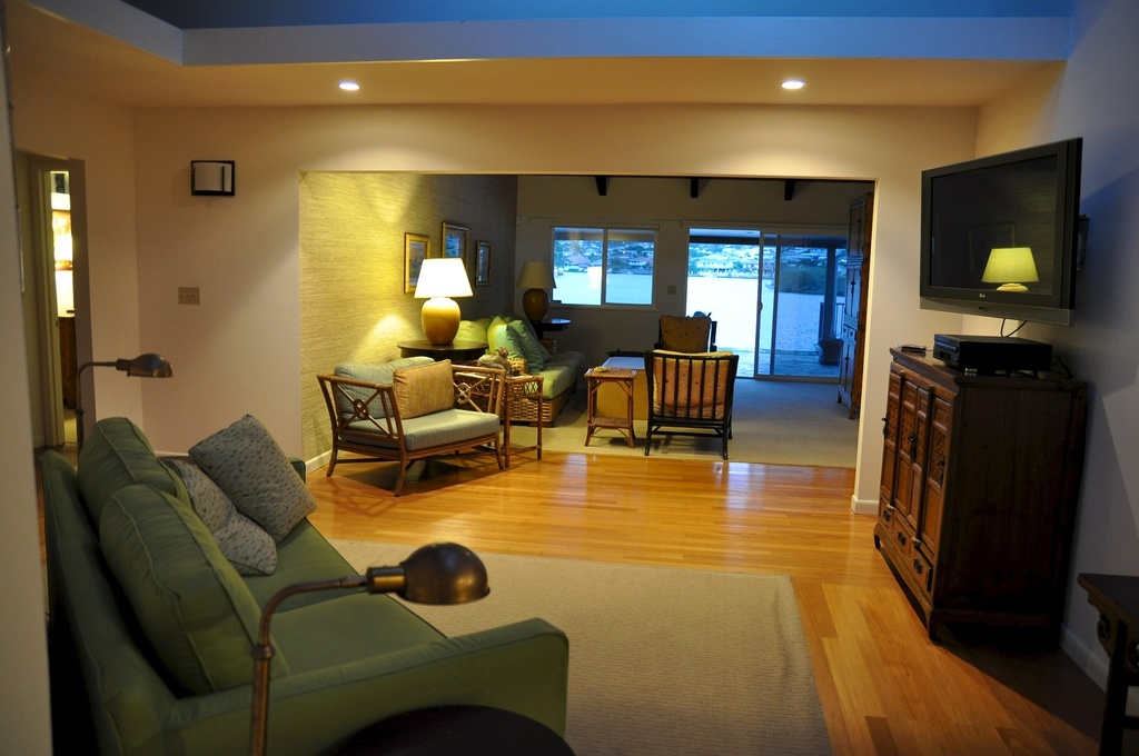 Ein Sofa mit zwei Kissen und einem Fernseher im Hintergrund.