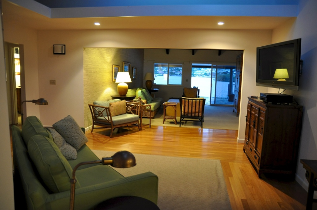 Ein Sofa mit zwei Kissen und einem Fernseher im Hintergrund.