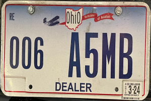 Ein Kennzeichen auf der Rückseite eines Autos mit Text und Zahlen.