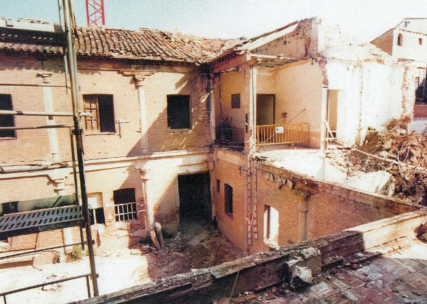 Ein teilweise abgerissenes Gebäude mit einer Barrikade, sichtbaren Fenstern und etwas, das wie eine Leiter aussieht.