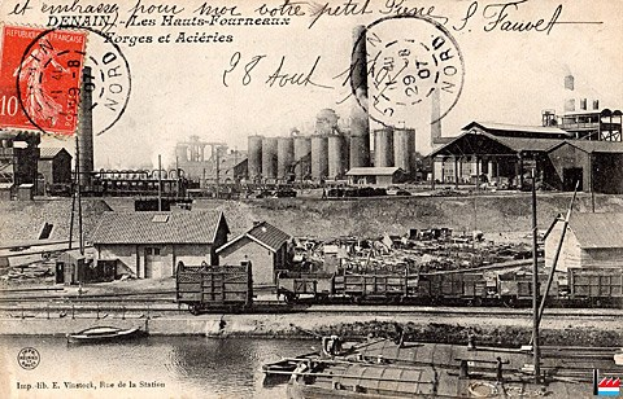 Alte Postkarte mit einer Fabrik im Hintergrund, Häuser, Masten, Schiffe und Wasser, mit Stempeln und Text.