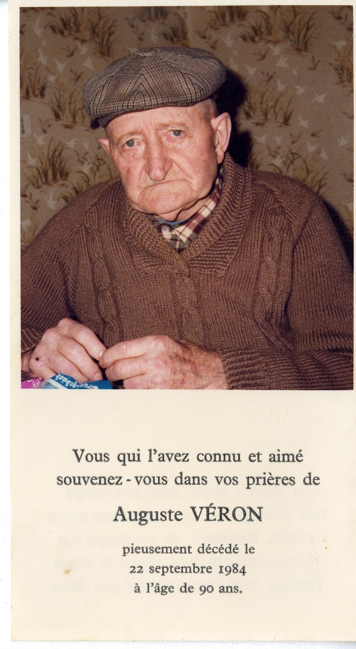 Ein älterer Mann in einem braunen Pullover und einer Mütze hält eine Geburtstagseinladungskarte mit seinem eigenen Foto.